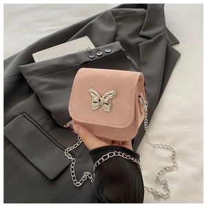 Detail van een roze mini-crossbodytas met metalen vlindergesp en een fijne schakelketting