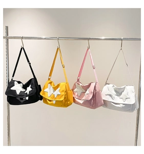 Row of colorful messenger bags with plush star patches in black, yellow, pink and white