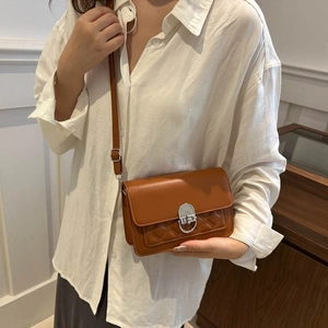 Classic caramel brown crossbody bag with quilted rhombus stitching and silver twist lock