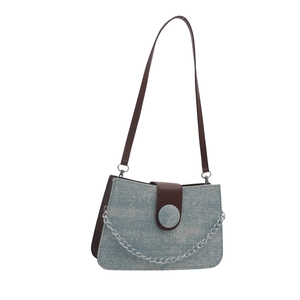 Blue denim crossbody bag with white polka dots and brown leather strap and chain