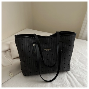 Détail du sac cabas gris avec motifs de petits chiens et étiquette en cuir noir chic
