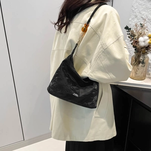 Classic black tote bag with unique crinkled texture and amber resin bead straps for women