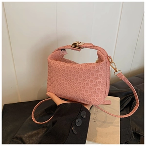 Close-up of pink woven texture handbag with pale gold hardware and top handle detail