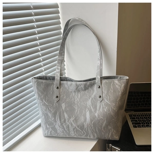 Detail of grey tote bag showing marble textured faux leather and silver metal rivets