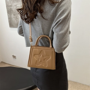 Chic brown star embossed crossbody bag styled with casual knitwear for women