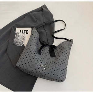 Detail of grey tote bag with heart patterns, satin bow and metallic logo detail