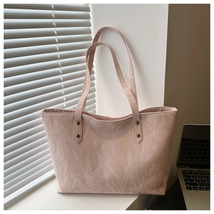 Detailed texture of pink tote bag with marble effect PU leather and silver studs