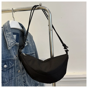 Detalle del bolso media luna de nailon negro con cremallera y correas finas para el hombro