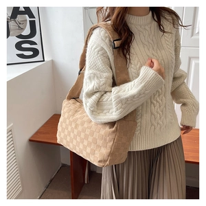 Détail du sac cabas beige tressé à damier avec large bandoulière pour le style d'automne