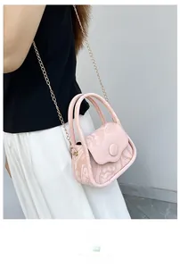 Detail of pink marble pattern crossbody bag with golden chain and rolled top handle