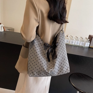 Gray heart print tote bag featuring a large black bow shoulder strap and silver accent