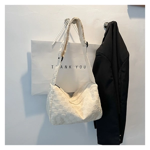 Détail d'un sac à bandoulière blanc tressé à damier au style minimaliste moderne
