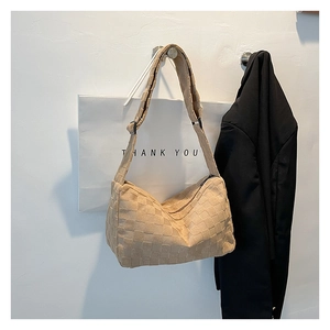 Détail de la texture tressée beige et de la fermeture éclair sur le sac demi-lune chic