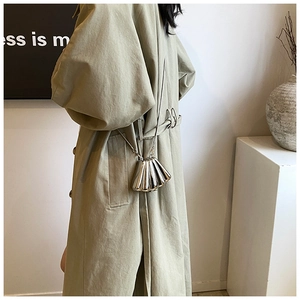 Chic silver mini shell crossbody bag with fine chain strap shown on a model outfit