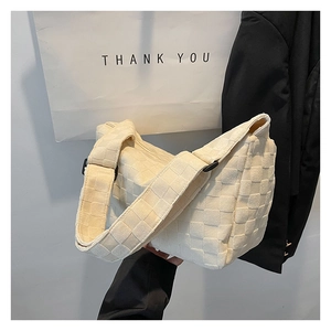 Vue détaillée de la texture tressée à damier crème et de la boucle de bandoulière réglable