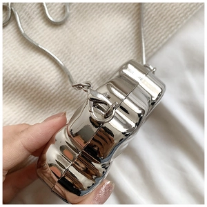 Detail of silver wavy hardshell crossbody bag with glossy mirror finish and snake chain