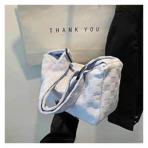 Détail d'un sac à bandoulière tressé bleu clair avec sangle réglable et boucle noire