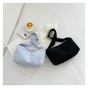 Détail de la texture tissée en damier sur les sacs fourre-tout bleu clair et noirs