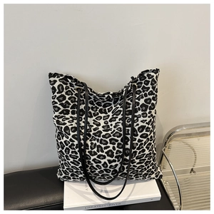 Détail du grand sac cabas en toile léopard avec fines lanières noires et texture tissée