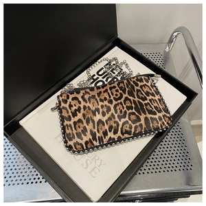 Close-up of leopard print crossbody bag with silver bead trim and metal chain strap