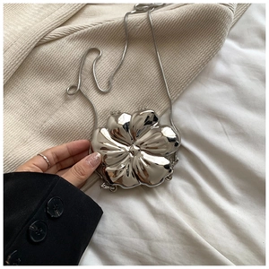 Close-up of a silver flower-shaped mini crossbody bag with a sleek snake chain strap