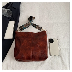 Close-up of vintage brown lychee grain faux leather tote with ethnic geometric wide strap