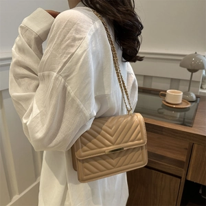Elegant beige quilted crossbody bag with V-shaped texture and gold chain strap for women