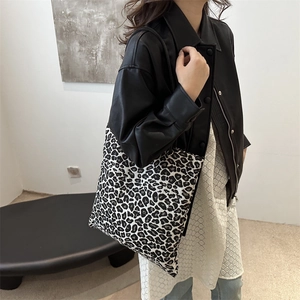Grand sac cabas en toile à imprimé léopard porté à l'épaule par un mannequin chic