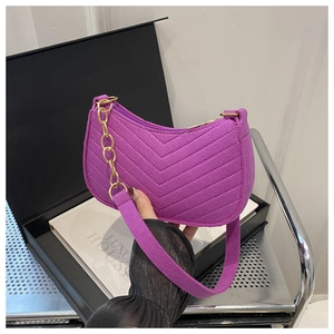 Detail of purple quilted velvet bag with V-stitch pattern and gold chain strap