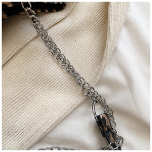 Detail of silver chain strap and leopard print fabric on a stylish shoulder bag