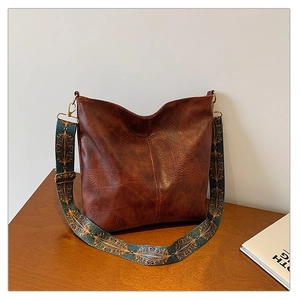 Detail of vintage brown tote bag featuring ethnic geometric embroidered wide shoulder strap