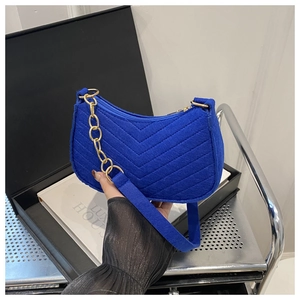 Close-up of Klein Blue felt shoulder bag with V-quilted texture and gold chain detail