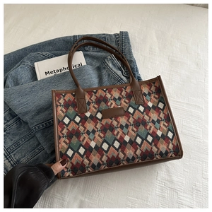 Close-up of woven tote bag with vintage geometric diamond patterns and leather trim