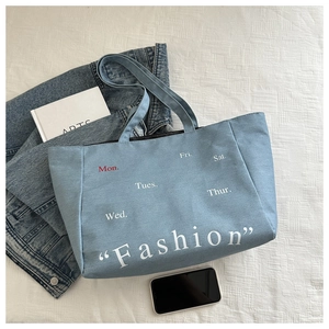 Détail du sac cabas en denim bleu clair avec lettrage Fashion et jours de la semaine