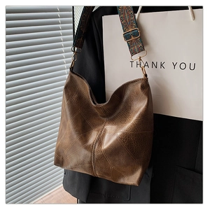 Detail of dark brown faux leather hobo bag with bohemian printed wide shoulder strap