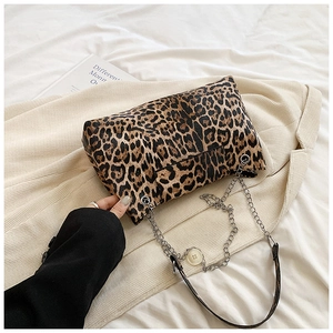 Detail of leopard print handbag with silver chain strap on corduroy jacket