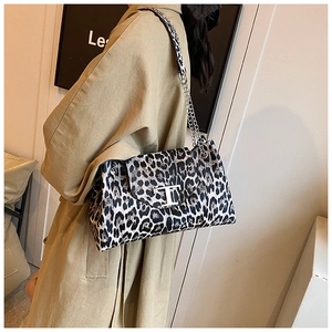 Close-up of leopard print shoulder bag featuring a silver chain and metal T-logo buckle