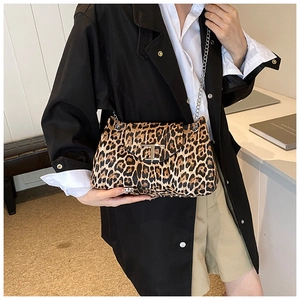 Detailed view of leopard print bag featuring a gold T-shaped metal clasp and chain strap