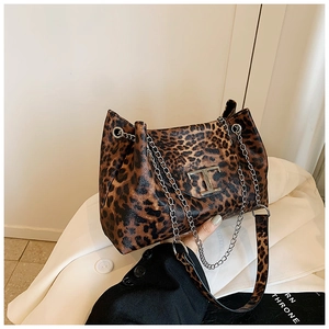 Detail of leopard print handbag featuring a silver T-shaped metal clasp and chain strap