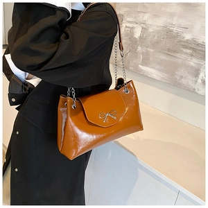 Sac porté épaule caramel avec nœud en métal et bandoulière chaîne sur un modèle