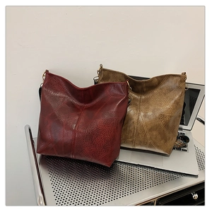 Close-up of litchi grain texture and patchwork stitching on vintage oversized hobo bags
