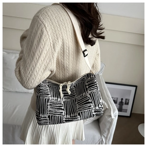 Detail of striped jacquard tote bag with adjustable strap shown on model shoulder