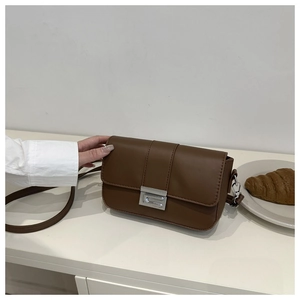 Dettaglio della borsa a tracolla vintage in pelle PU marrone con chiusura girevole
