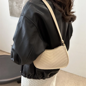 Chic beige chevron quilted half-moon shoulder bag styled with a modern black leather jacket