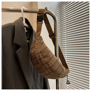 Détail du sac banane tissé marron avec texture en tricot et sangle réglable à boucle