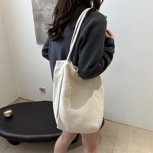 Minimalist cream canvas tote bag with striped texture and rope shoulder straps