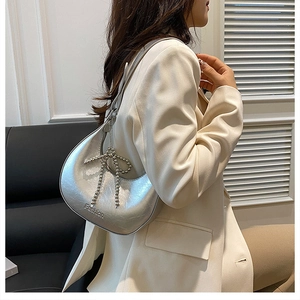 Detail of silver crescent hobo bag with pearl bow decoration and Fashion embossing