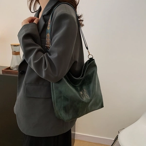 Dark green retro leather tote bag with embroidered wide strap shown on a model
