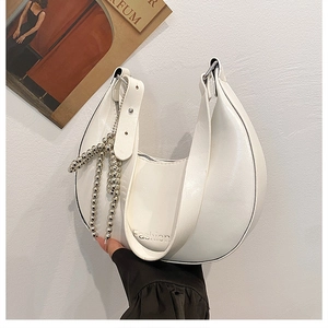 Close-up of white semi-circle hobo bag featuring glossy finish and silver beaded chain