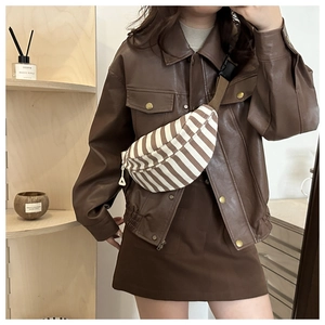 Detailed view of a brown striped crescent crossbody bag with adjustable fabric strap